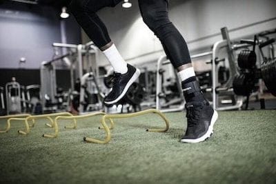 En person, der bruger en støttebandage, mens han laver en squat i et fitnesscenter.